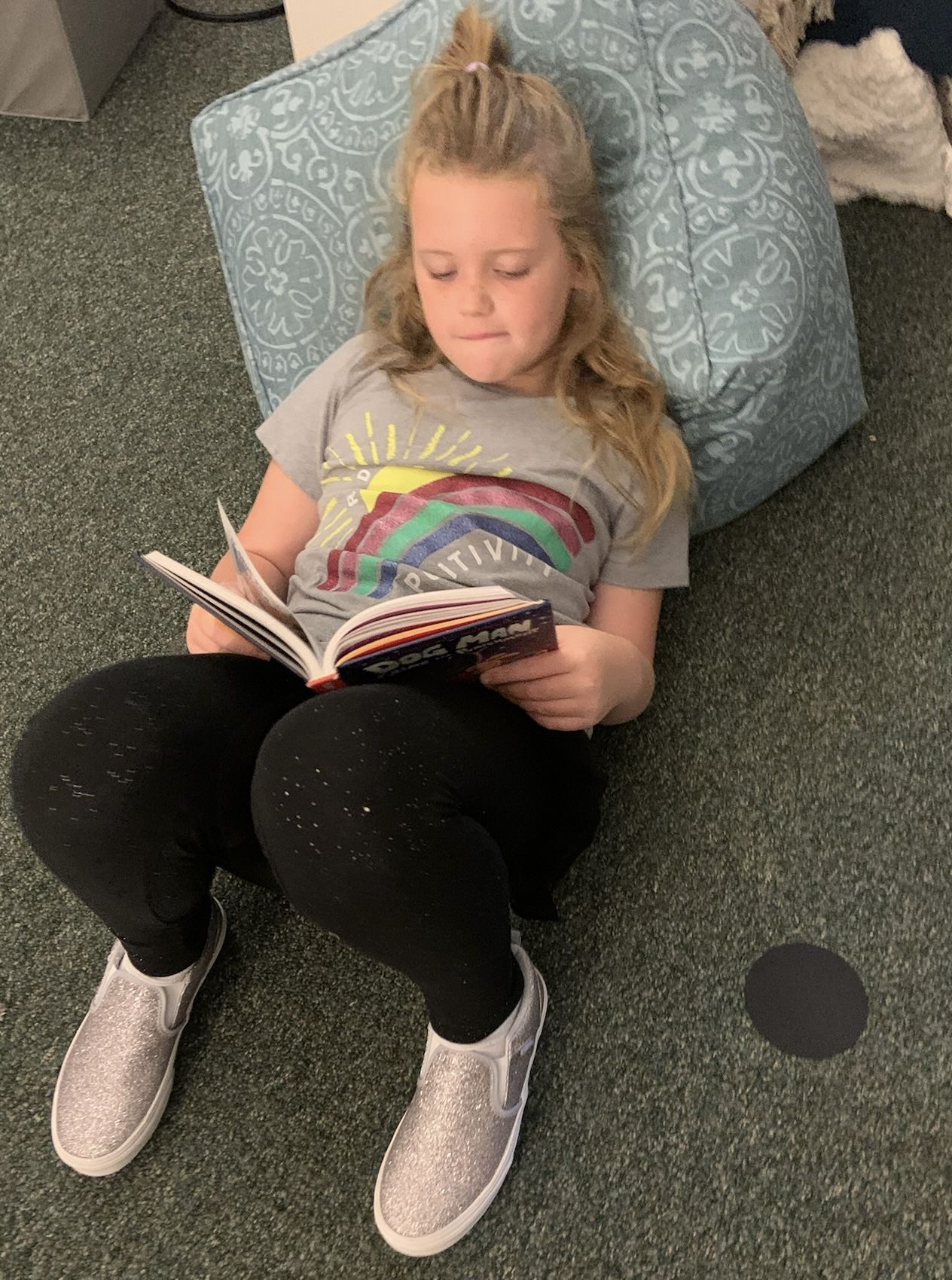 Female child reading a book laying down