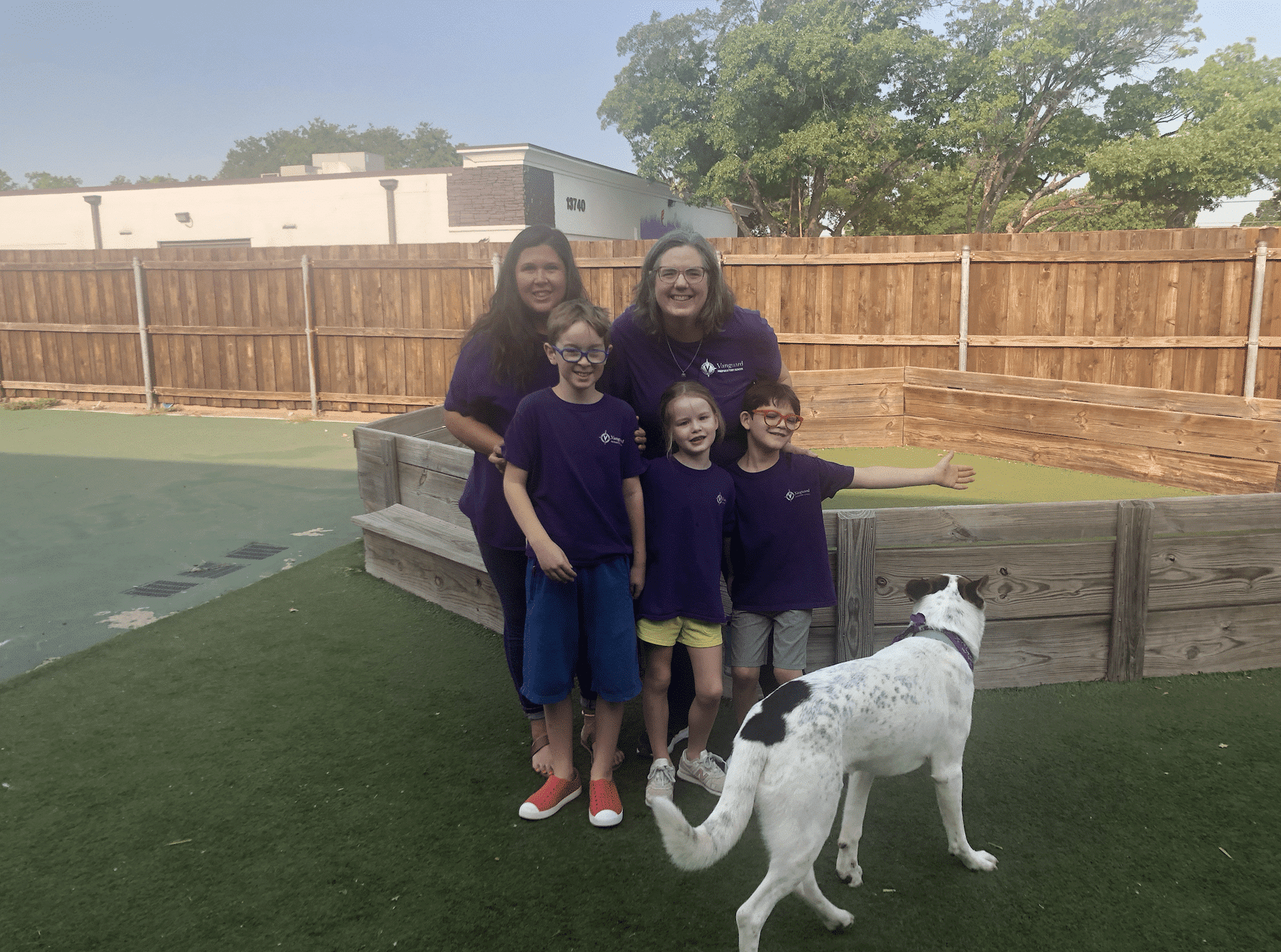 teachers and students with a dog posing and smiling