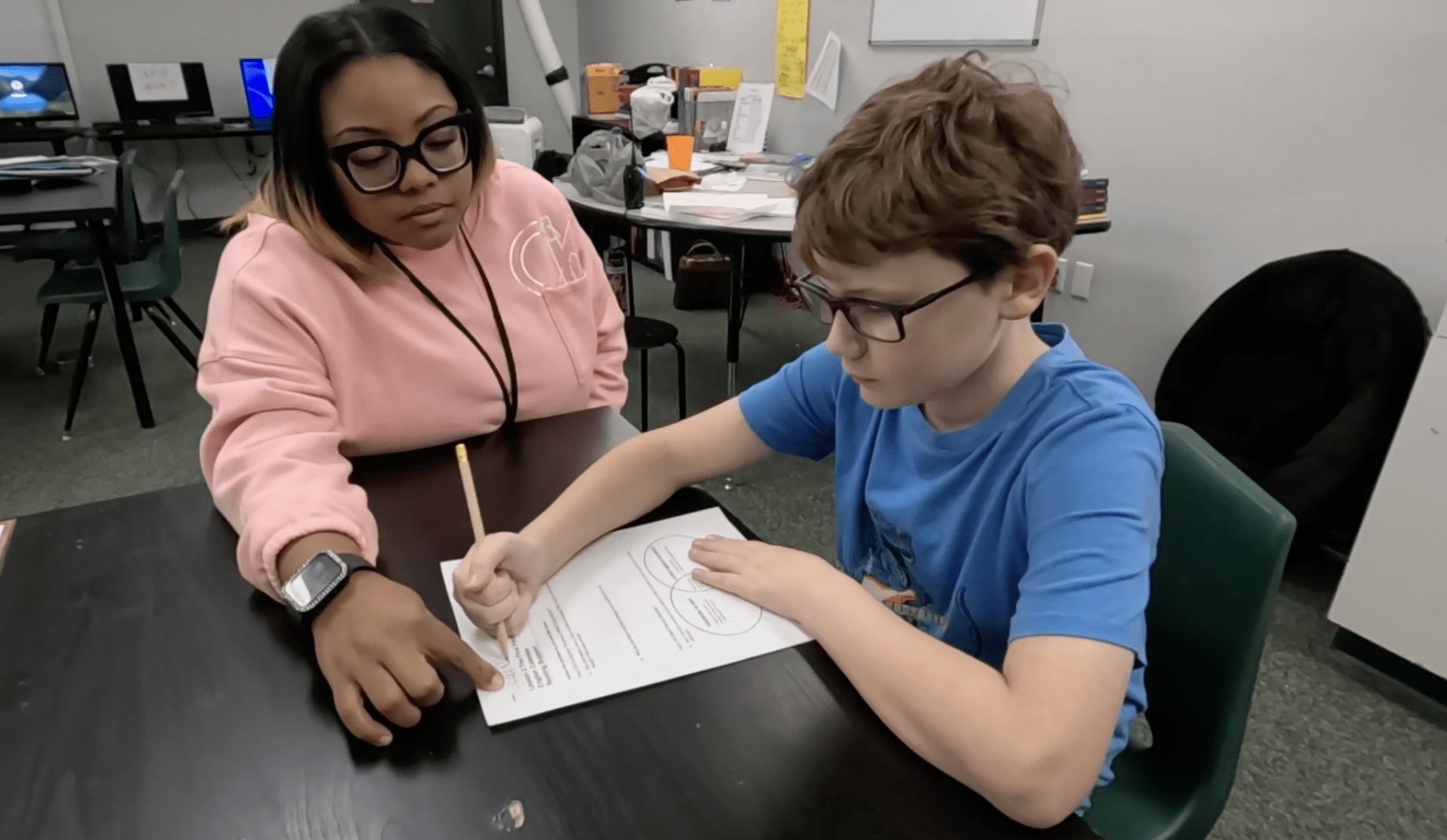 teacher instructing a kid on writing